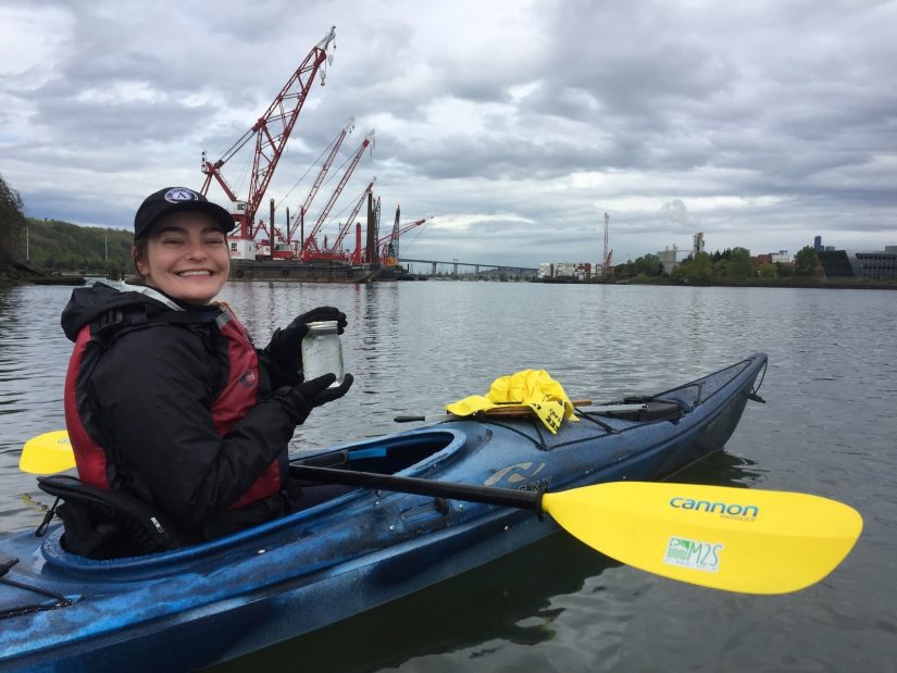 Woman in a kayak collecting a water sample