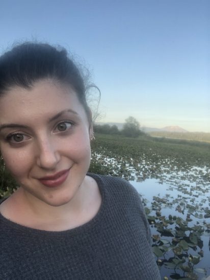 A selfie of Nikki Canning standing in front of wetlands at Seaquest State Park.