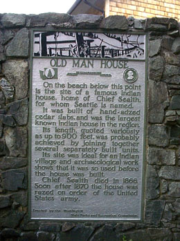 A silver plaque against against a stone wall commemorating Old Man House.