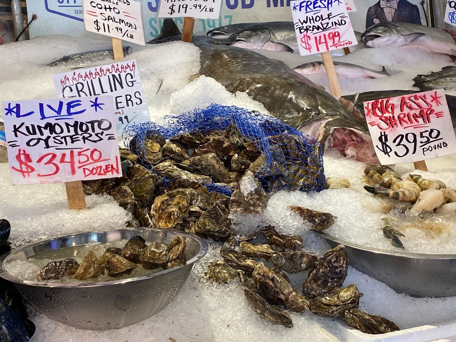 Oysters spill out of mesh bags and cascade down piles of crushed ice at a stall at Pike Place Market in Seattle.
