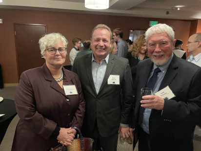 Nives Dolsak, Steve Metruck and Dave Fluarty standing and posing for a photo at the reception