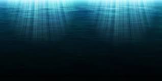 Sunlight beams penetrate deep blue ocean waters, creating an ethereal and tranquil underwater scene with a sense of calm and mystery.